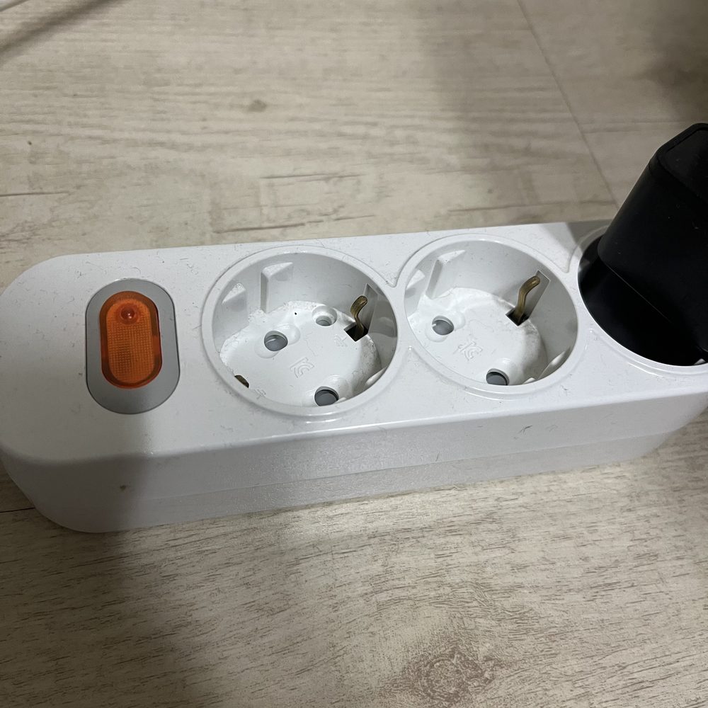 A Korean power strip with two recessed Type F sockets, one holding a plug, photographed at home